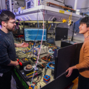 Image showing two students, one male and one female, chatting against a lab background
