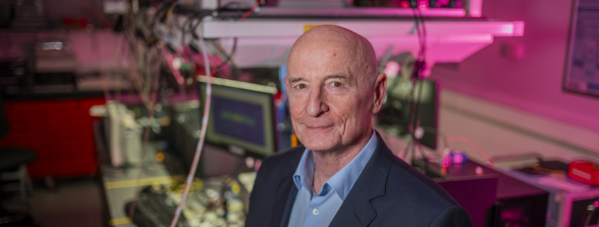Image of a white, middle aged bald man in a science lab