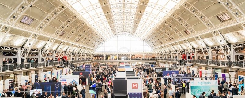 Image is a photo of a previous Showcase, showing great attendance and lots of stalls for people to visit