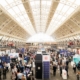 Image is a photo of a previous Showcase, showing great attendance and lots of stalls for people to visit
