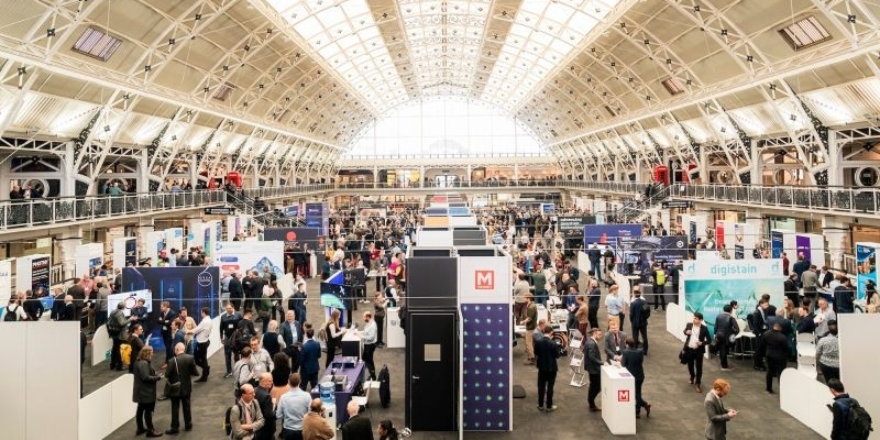 Image is a photo of a previous Showcase, showing great attendance and lots of stalls for people to visit