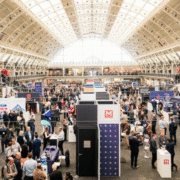 Image is a photo of a previous Showcase, showing great attendance and lots of stalls for people to visit